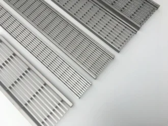 Recessed stainless steel drain grating for a hidden, seamless drainage look in gardens.